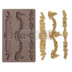 May include: A silicone mold for creating decorative cake borders. The mold features three designs of ornate, gold-colored, leaf-shaped borders with a central medallion.