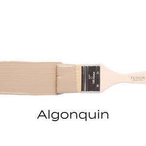 May include: A paint swatch of Fusion Mineral Paint in the color Algonquin. The paint is a light beige color and is shown on a paint brush.