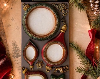 May include: A grey silicone decor mould sheet labeled Noel Elegance featuring various Christmas ornament shapes including a large round frame, a teardrop shape, a star, and smaller decorative accents like a pine tree and a snowflake.