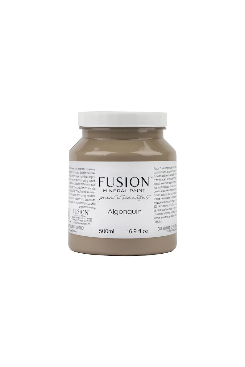 May include: A 16.9 fluid ounce bottle of Fusion Mineral Paint in the color Algonquin. The paint is a light brown color and is labeled with the Fusion logo and the name of the color.
