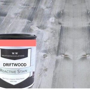 May include: A can of Driftwood Reactive Stain by Weatherwood Stains. The can is black with white text and a red stripe. The text reads "Driftwood Reactive Stain" and "Non-Toxic | Interior | Water-Based | VOC Free".
