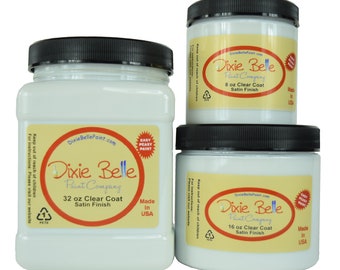 May include: Three white plastic jars of Dixie Belle Paint Company clear coat in satin finish. The jars are labeled with the size of the paint in ounces: 8 oz, 16 oz, and 32 oz. All jars have a red and yellow label with the Dixie Belle logo and the words "Easy Peasy Paint".