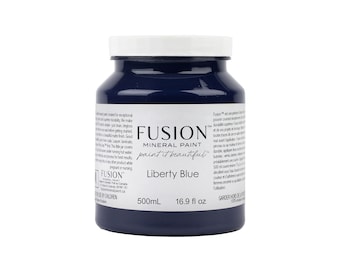 May include: A 16.9 fluid ounce bottle of Fusion Mineral Paint in the color Liberty Blue. The bottle is blue and has a white label with the Fusion logo and product information.