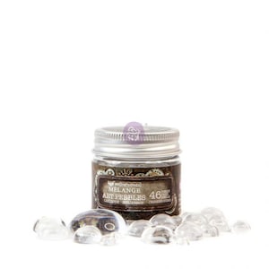 May include: A small glass jar with a silver lid contains clear glass art pebbles. The jar has a brown label that reads "Art Impressions Melange Art Pebbles 46 Pieces Cailloux Bouillonne Various Sizes".