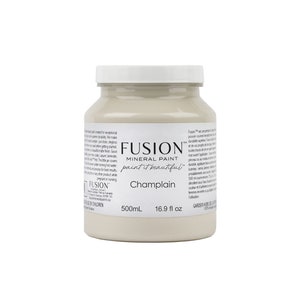 May include: A 16.9 fluid ounce bottle of Fusion Mineral Paint in the color Champlain. The bottle is white with a black label and the text "Fusion Mineral Paint paint it beautiful" and "Champlain".