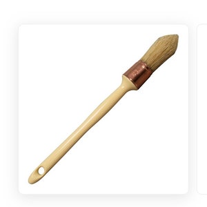 May include: A wooden-handled paint brush with a white bristle head and a copper ferrule.