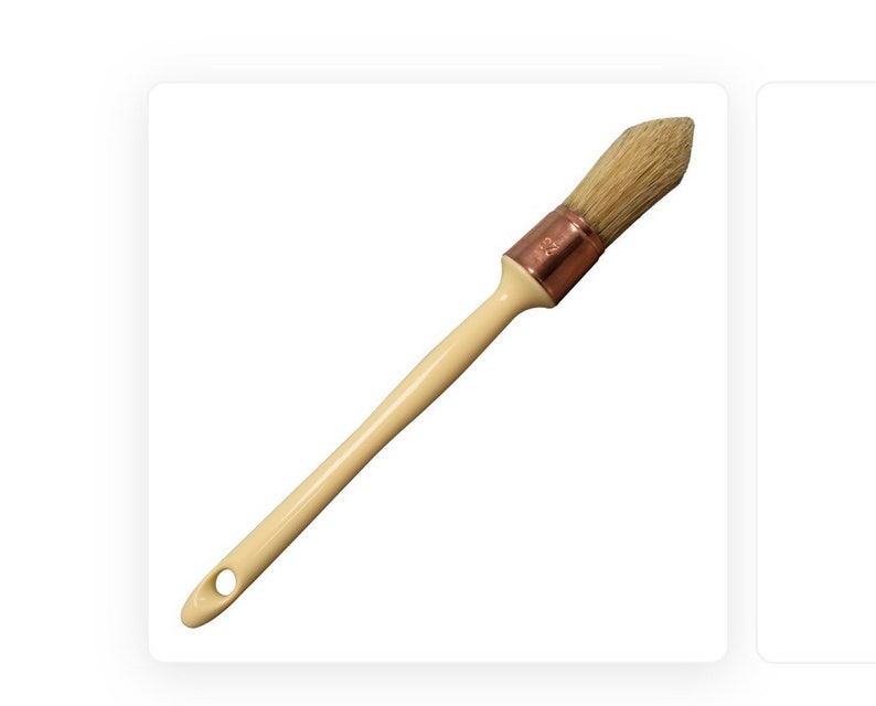 May include: A wooden-handled paint brush with a white bristle head and a copper ferrule.