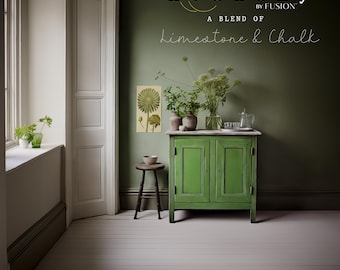 May include: A green cabinet with two doors stands against a dark green wall. The cabinet is topped with a white surface, and a small wooden stool sits nearby. The wall features the text "Alchemy by Fusion" and "A Blend of Limestone & Chalk."