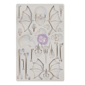 May include: White silicone mold with multiple designs of skulls, bones, and wings. The mold is designed for baking and decorating cakes and other desserts.