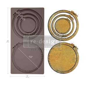 May include: A rectangular brown silicone mold measuring 10 inches by 5 inches, featuring circular embroidery hoop designs. Beside it are finished gold-toned circular castings with wood-grain textures and floral details, matching the mold's shapes.