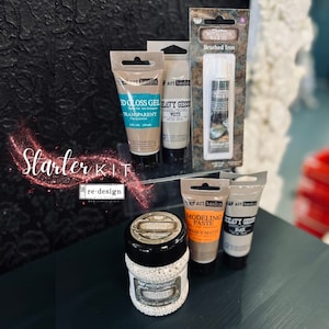May include: A starter kit for crafting and DIY projects, featuring a variety of art supplies including modeling paste, heavy gesso, 3D gloss gel, metallic wax, and white pearl beads. The kit includes the text "re-design simplified".