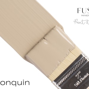 May include: A close-up of a paint brush with a light beige paint sample. The paint is labeled "Algonquin" and the brand is "Fusion Mineral Paint, Paint it beautiful."