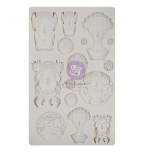 May include: Silicone mold with 11 different designs of women's faces, including a woman with a crown, a woman with a flower in her hair, and a woman with a veil. The mold is white and has a textured surface.