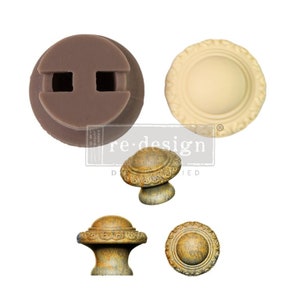 May include: Two silicone molds for making decorative knobs. One mold is brown and has two holes. The other mold is cream colored and has a raised circular design. There are three finished knobs, two with a brown and gold finish and one with a gold finish. The knobs have a raised circular design.