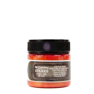 May include: A small jar of red acrylic paint with a metallic finish. The label reads "art alchemy SPARKS Phoenix Feather Plume de Phénix Pluma de Fénix 1.7 FL. OZ. (50 ml)"