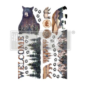 May include: A sheet of decorative decals featuring a black bear, paw prints, trees, and the word "WELCOME." The bear has a detailed design with a forest scene. Other elements include a plaid bear, a wooden bear, and a mountain scene.