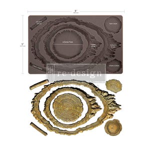 May include: A brown silicone mold measuring 8 inches by 5 inches, featuring recessed cavities for casting tree ring and branch shapes. Below the mold are gold-colored cast pieces matching the shapes, including a large central tree ring.