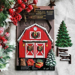 May include: A brown silicone mold for crafting, labeled Homestead Holiday, featuring a red barn with white trim, wreaths, lanterns, a Christmas tree, a sack, a poinsettia, and gifts. The packaging indicates a 5 inch by 8 inch size for the mold.