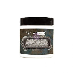 May include: A white jar of modeling paste with a black lid. The label is blue and brown with the text "art basics Modeling Paste Pâte de Structure Pasta de Modelado Opaque MatteOpaque Mat Opaco Mate 8FL.OZ(236 ML)"