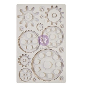 May include: White silicone mold with a design of nine different sized gears. The mold is for making cake decorations or other edible items.