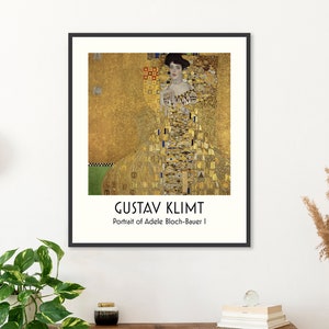 May include: A black framed poster featuring a painting by Gustav Klimt titled "Portrait of Adele Bloch-Bauer I". The painting depicts a woman in a gold dress with a gold background.