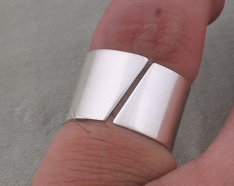 Puede incluir: Un anillo de plata con un diseño único, que presenta dos piezas rectangulares planas unidas con un pequeño espacio en el medio.