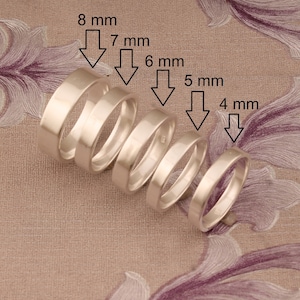 Peut inclure: Cinq bagues en argent de différentes largeurs, allant de 4 mm à 8 mm. Les bagues sont disposées par ordre de taille, la plus petite à droite et la plus grande à gauche.