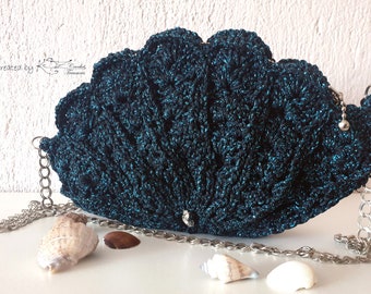 May include: A teal blue crocheted purse shaped like a seashell with a silver chain strap. The purse has a sparkly finish and a silver clasp.