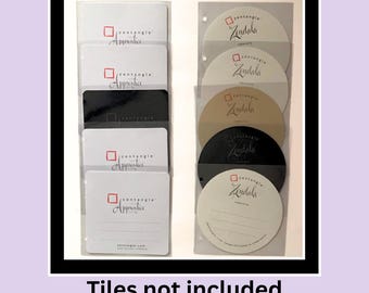 May include: A set of square and circular paper tiles for drawing, featuring the Zentangle Apprentice and Zindala logos in red and black. The square tiles are white and black, while the circular tiles are white, tan, and black, all organized.