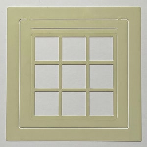 May include: A light green square stencil featuring a grid of nine white squares. The stencil has a raised border, suitable for crafts or art. The design is symmetrical and clean, ideal for various creative applications.