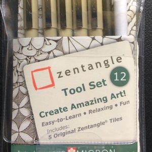 Könnte beinhalten: Ein Zentangle Tool Set in einer transparenten Kunststoffverpackung. Das Set enthält Stifte, einen Bleistift, einen Tortillon und Kacheln. Auf der Verpackung steht "Zentangle Tool Set 12 Create Amazing Art! Easy-to-Learn • Relaxing • Fun."