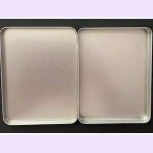 Silver coloured rectangular shaped tin with hinge lid for stationery