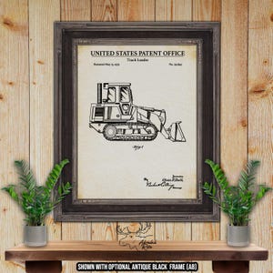 May include: Black and white line drawing of a track loader patent. The patent is titled "Track Loader" and was patented on May 15, 1979. The patent number is 454,849.