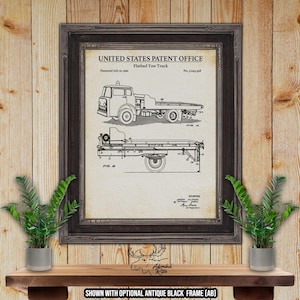 May include: A black and white line drawing of a flatbed tow truck patent. The patent is titled "Flatbed Tow Truck" and the patent number is "No. 1,043,458". The patent was issued on July 10, 1961.