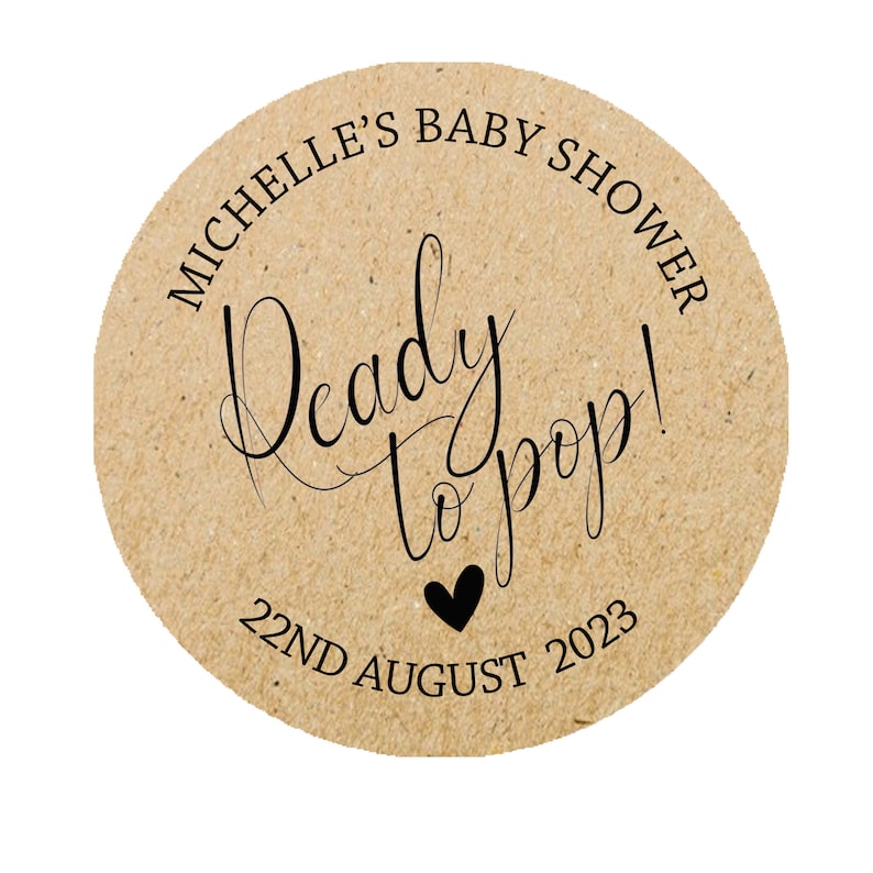 May include: Round brown paper sticker with the text "Michelle's Baby Shower" and "Ready to pop!" with a small black heart and the date "22nd August 2023".