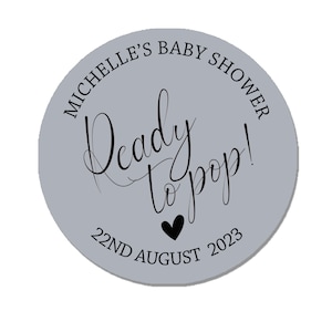 May include: A gray circle sticker with the text "Michelle's Baby Shower" and "Ready to pop!" in black cursive font. The date "22nd August 2023" is also printed in black.