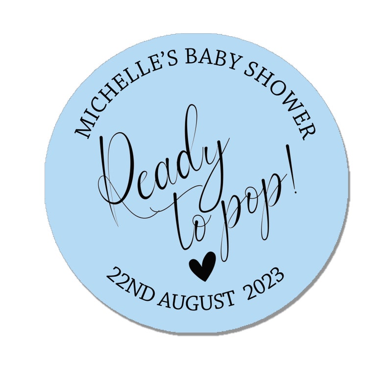 May include: Light blue circle sticker with the text "Michelle's Baby Shower" and "Ready to pop!" in black script. The date "22nd August 2023" is printed below the text with a small black heart.