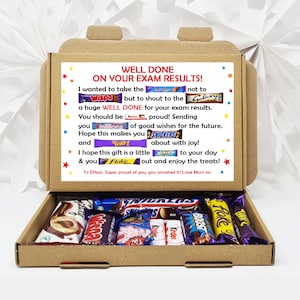 May include: A brown cardboard box with a white card inside. The card has a message that says "Well Done on Your Exam Results!" and is decorated with various chocolate bar wrappers. The box is open and contains a variety of chocolate bars.