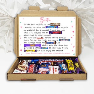 Puede incluir: Una caja de regalo de cart&oacute;n marr&oacute;n llena de varias barras de chocolate y caramelos. La tapa de la caja tiene un mensaje impreso con la palabra "Bestie" y una felicitaci&oacute;n de cumplea&ntilde;os. La caja est&aacute; abierta, revelando los dulces.