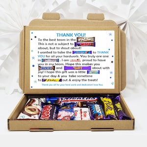May include: A brown cardboard box with a thank you message and a variety of chocolate bars inside. The message reads "Thank you! To the best team in the Galaxy... You truly are one in millions. I am proud to have you in my team. Hope this makes you about with joy! I hope this gift was a little boost to your day & you take sometime to flake out & enjoy the treats! Thank you all for your hard work and dedication! love Ross".