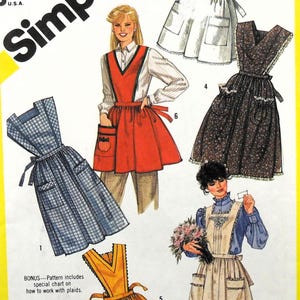 May include: Simplicity sewing pattern featuring various apron designs. The image showcases aprons in different styles and colors, including a red apron with a pocket, a blue plaid apron, and a yellow apron. The pattern includes a special chart on how to work with plaids.