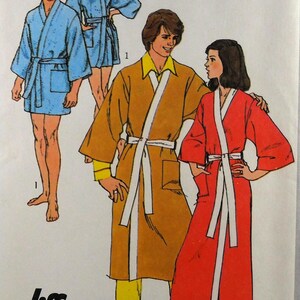 May include: A vintage sewing pattern with illustrations of bathrobes in blue, gold, and red. The robes have white trim and belts. The "Jiffy" logo is in the bottom left corner, and the pattern number is "9507". The image shows the robes being worn.
