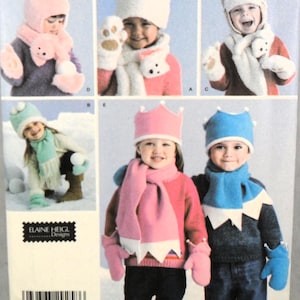 May include: A sewing pattern envelope by Elaine Heigl Designs featuring illustrations of children wearing various handmade winter accessories including hats, scarves, and mittens. The designs include animal-themed sets, crown-topped hats, and scarves with pom-poms, showcasing multiple color combinations and styles for cold weather apparel.