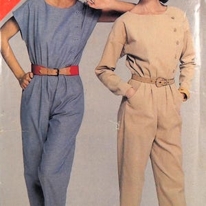 Puede incluir: Dos mujeres modelando dos estilos diferentes de monos. La mujer de la izquierda lleva un mono azul claro con un cinturón rojo. La mujer de la derecha lleva un mono beige con un cinturón marrón. El número de patrón 5316 y la talla B (14-16-18) están impresos en rojo en la esquina superior izquierda de la imagen.