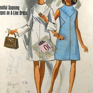 May include: Illustration of two women modeling A-line dresses. One woman wears a white dress with long sleeves, the other a light blue dress. The image includes text: "Beautiful Seaming Shapes an A-Line Dress."