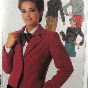 May include: A sewing pattern envelope featuring a red blazer with a notched lapel, worn over a white collared shirt with a dark patterned bow tie. The envelope includes illustrations of three additional jacket variations in black, gray, and dark brown.