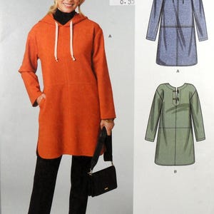 Puede incluir: Una túnica con capucha naranja con cordones blancos, combinada con pantalones negros y un bolso negro. La imagen también muestra dos diseños de patrones de túnica en azul y verde. El precio es "8.99".