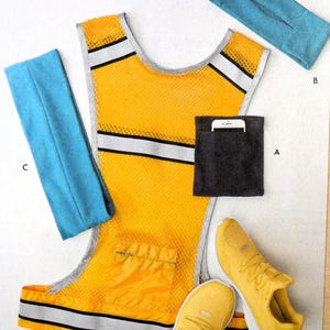May include: A yellow safety vest with reflective strips, a black pocket with a white phone inside, two yellow running shoes, and three blue headbands.