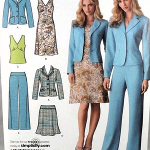 May include: A Simplicity sewing pattern featuring various women's clothing designs. The designs include a light blue blazer, a floral print dress, a green top, and light blue pants and skirt. The pattern also includes a tweed blazer and skirt. The website address is simplicity.com.