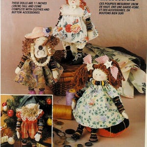 May include: Four fabric dolls, each 11 inches tall, featuring yarn hair, dresses with floral or paisley patterns, and limbs decorated with stacked buttons. One doll wears a hat, another a lace collar, and one stands near a Christmas tree.